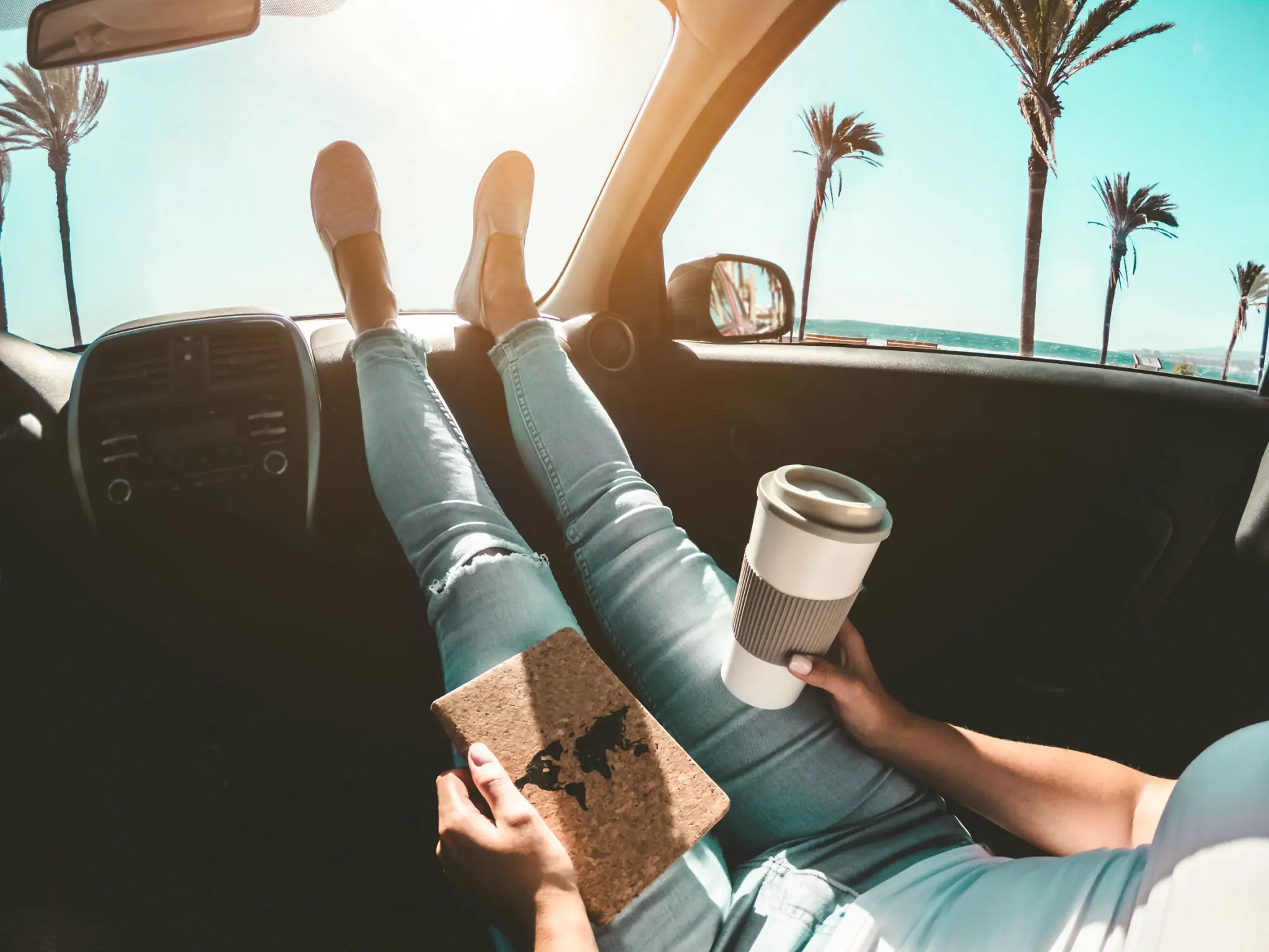 Relaxing road trip moment with coffee and a notebook.
