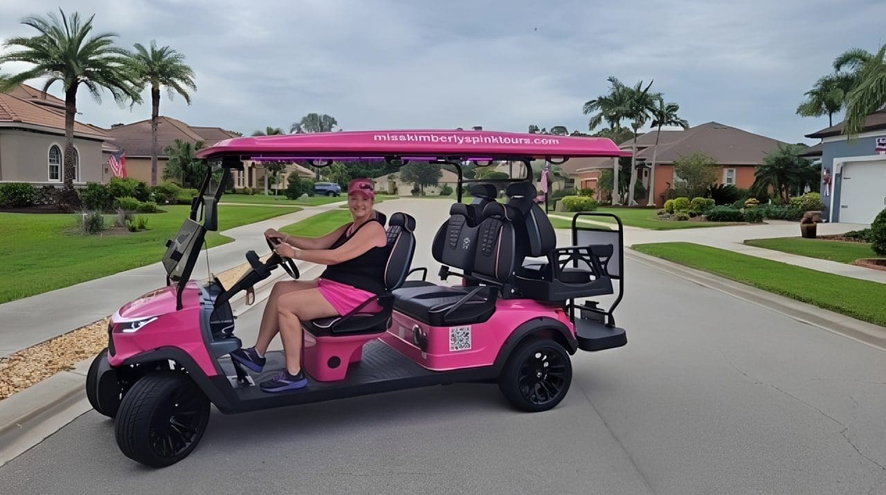 Person driving pink golf cart in neighborhood